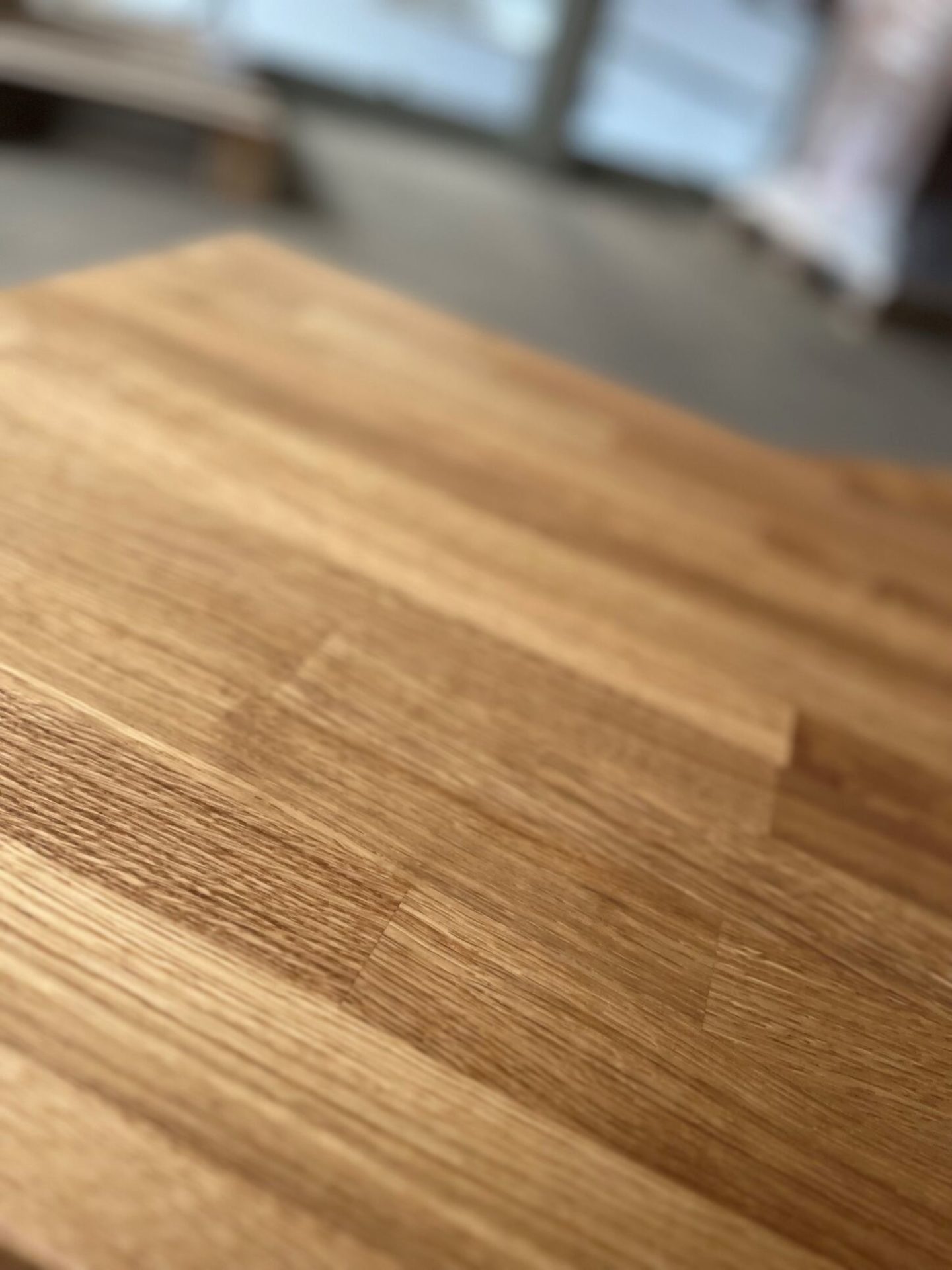 Detailaufnahme einer massiven Holzplatte mit natürlicher Maserung und warmem Farbton